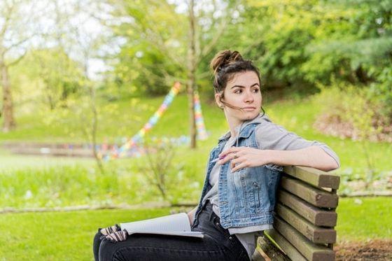 Photo of a female Chatham University student sitting on a bench outside on 足球波胆平台